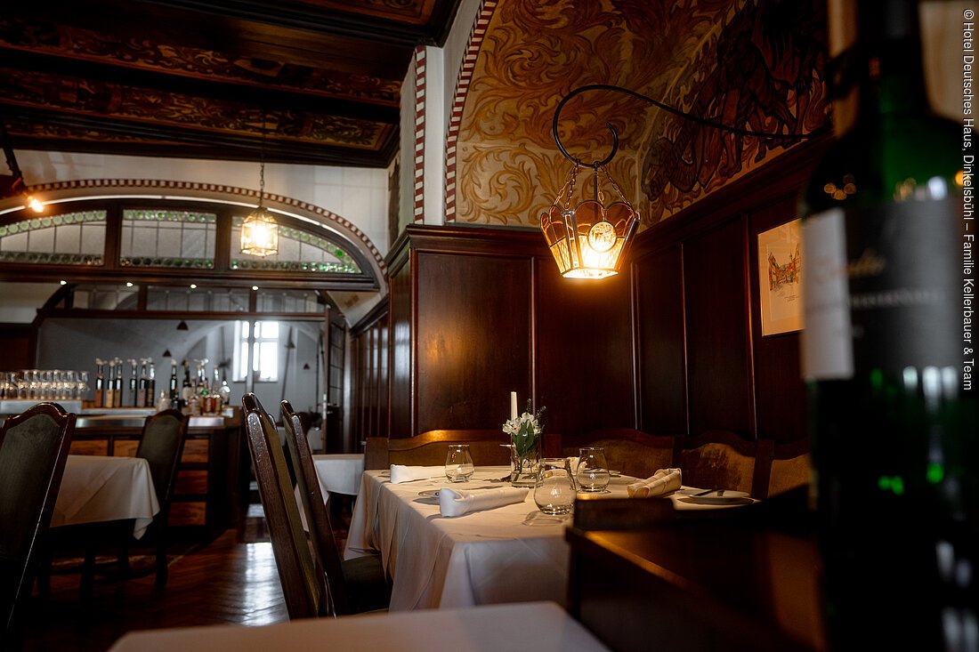 Restaurant mit Holzwänden, gedecktem Tisch, Kerzenlicht und dekorativer Decke.